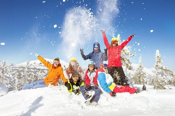 Happy skiers and snowboarders having fun at ski resort. Winter vacations concept